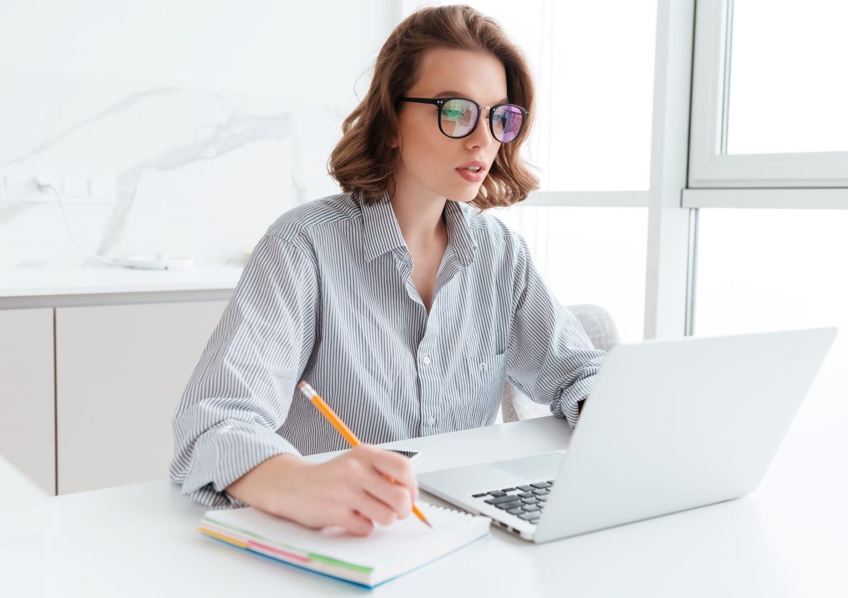 Девушка в очках за ноутбуком