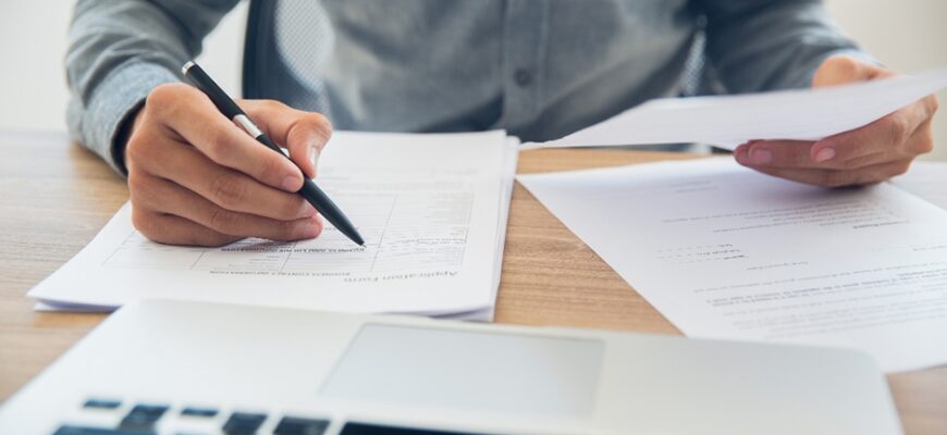 Мужчина разбирает документы